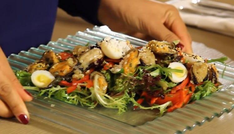 Cospargi l'insalata finita con le cozze con semi di sesamo.