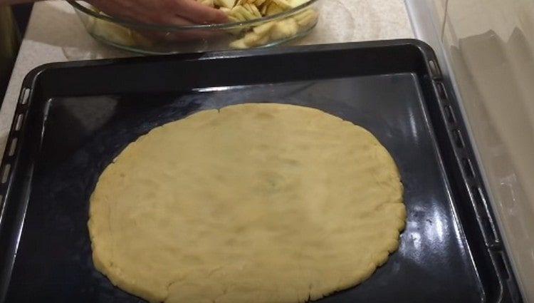 Dall'impasto su una teglia formiamo una base rotonda per la torta.