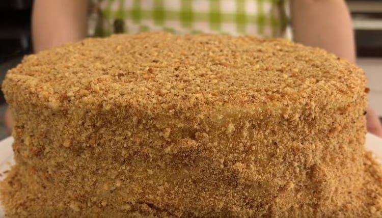 Cospargere la torta finita, cotta in padella, con briciole di biscotti di pasta frolla.