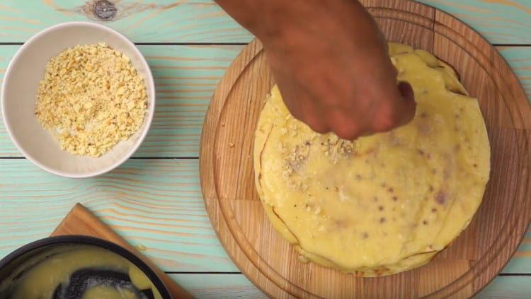 Cospargi i lati e la parte superiore della torta con le briciole da sotto le torte.