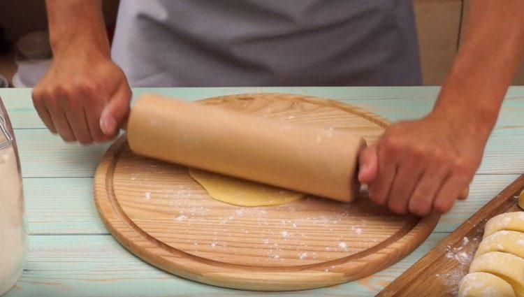 Stendiamo ogni porzione dell'impasto con un mattarello in una torta.