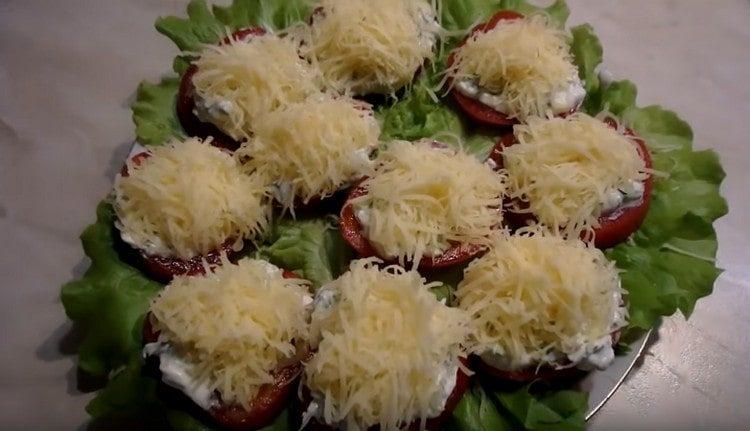 Cospargere i pomodori con formaggio grattugiato.