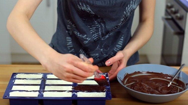 Copriamo gli spazi vuoti con glassa al cioccolato e mettiamo nel congelatore.