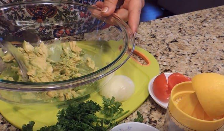 Impastare la carne di un avocado con una forchetta.