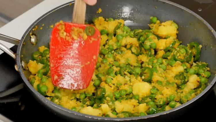 Metti le patate e i piselli in una padella.