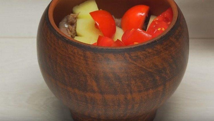 Sul fondo della teglia, mettete la salsa, il coriandolo tritato, la carne, le patate e i pomodori.