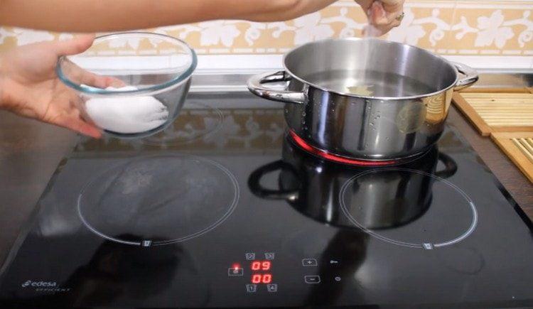 In una casseruola, portare ad ebollizione l'acqua, salarla, aggiungere grani di pepe e alloro.