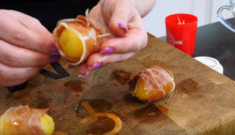 Fissare le patate con la pancetta con l'aiuto di stuzzicadenti.