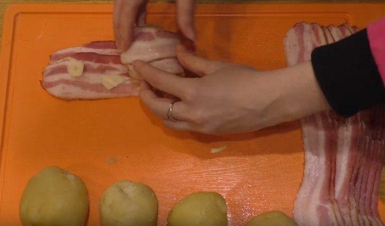 Metti l'aglio sulla pancetta e avvolgici le patate.