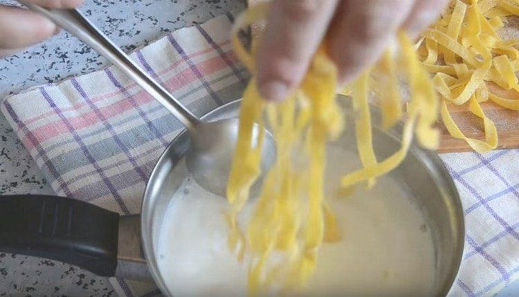 Metti le tagliatelle nel latte bollente.