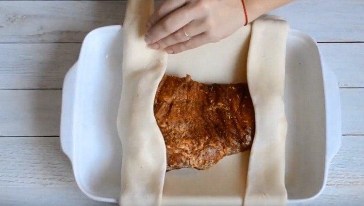 Distribuiamo la carne sull'impasto, avvolgendola con una busta.