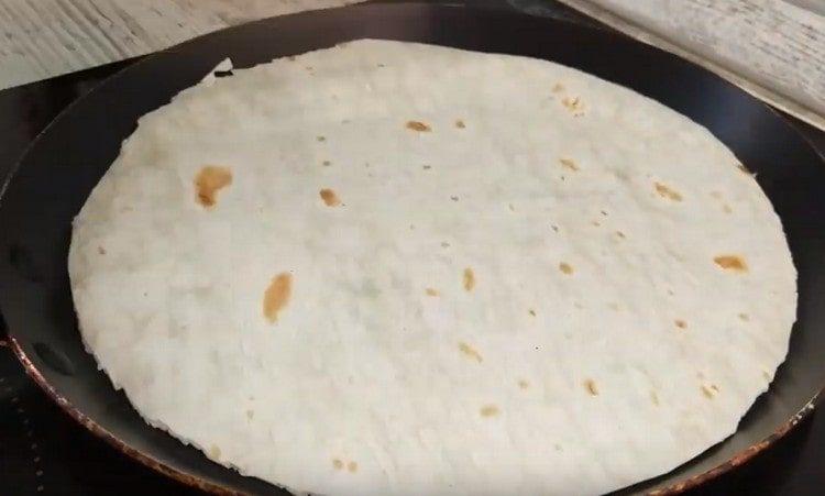 Distribuiamo il pane pita in una padella.