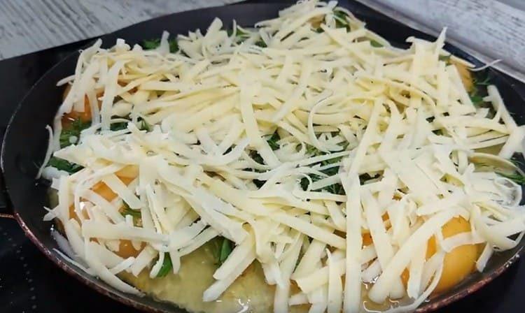 Cospargere immediatamente le uova con verdure e formaggio grattugiato.